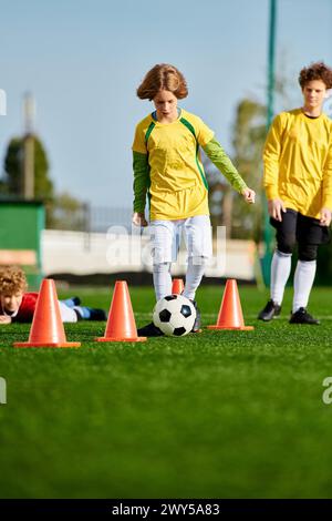 Un groupe de jeunes enfants, remplis d'enthousiasme, sont engagés dans un jeu de football animé. Ils courent, frappent le ballon, rient et applaudissent Banque D'Images