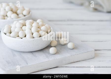 Cacahuètes recouvertes de soja blanc avec sauce dans un bol en bois, noix enrobée turque traditionnelle Banque D'Images