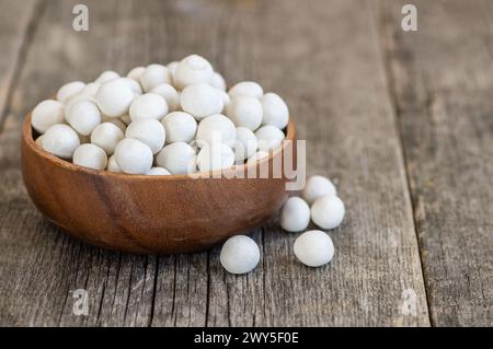 Cacahuètes recouvertes de soja blanc avec sauce dans un bol en bois, noix enrobée turque traditionnelle Banque D'Images