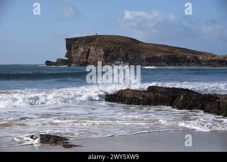 La baie d'Oldshoremore près de Kinlochbervie, avec Eilean na h-Aiteig, une île accessible à marée basse, comme le montrent les deux marcheurs au sommet de la colline. Banque D'Images