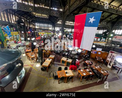 Vue intérieure sur le marché central de Santiago du Chili, sa statue le drapeau du Chili et le restaurant touristique et traditionnel Donde Augusto Banque D'Images