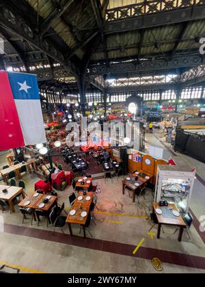 Vue intérieure sur le marché central de Santiago du Chili, sa statue le drapeau du Chili et le restaurant touristique et traditionnel Donde Augusto Banque D'Images