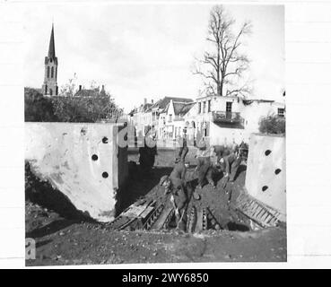 POUSSÉE BRITANNIQUE AU NORD DE MARK, HOLLANDE - les ingénieurs royaux remplissent le cratère soufflé dans la route, par les Allemands, à l'entrée de Willemstad, pour permettre au trafic WD de passer. , Armée britannique, 21e groupe d'armées Banque D'Images