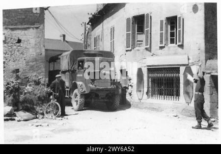 Un policier militaire dirige la circulation à Lantheuil, en Normandie, tandis qu'un véhicule lourd navigue dans un virage serré lors des opérations de l'armée britannique, 21e groupe d'armées. Banque D'Images