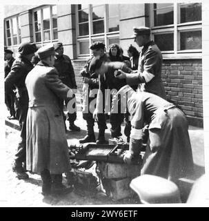 La police civile allemande est montrée en train de sécuriser leurs grenades sous observation par des parachutistes de la 6e division aéroportée britannique, qui fait partie du 21e groupe d'armées. Banque D'Images