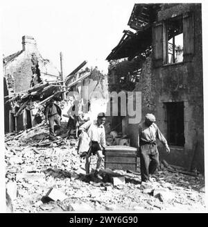 Une FAMILLE FRANÇAISE RETOURNE DANS LEUR VILLAGE DÉCHIRÉ DE COQUILLAGES - la famille porte ensuite les biens qu'elle a pu récupérer dans leur nouvelle maison. , Armée britannique, 21e groupe d'armées Banque D'Images