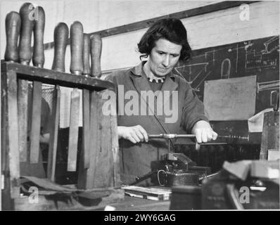 FORMATION POUR LE TRAVAIL DE GUERRE AU CENTRE DE FORMATION DU MINISTÈRE DU TRAVAIL DE CHELSEA POLYTECHNIC, LONDRES, ANGLETERRE, 1941 - Un stagiaire au Centre de formation du Ministère du travail de Chelsea Polytechnic fabrique un filetage dans l'atelier d'essayage du centre. , Banque D'Images