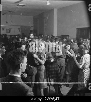 LES BÉNÉVOLES DU SERVICE DE LA JEUNESSE AIDENT LES AGRICULTEURS BRITANNIQUES : CAMP AGRICOLE À Nunney CATCH, SOMERSET, ANGLETERRE, Royaume-Uni, 1943 - les bénévoles du service de la jeunesse assistent à une danse qu'ils ont organisée dans la salle de village de Nunney Catch, Somerset. Beaucoup apprécient une danse avec une fille locale. , Banque D'Images