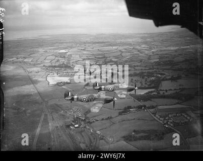 Trois Hawker Hurricane Mark IIBs du No. 79 Squadron RAF volent en formation 'vic' au-dessus du sud du pays de Galles, pilotés par le chef d'escadron G d Haysom et les commandants de vol R P Beamont et l T Bryant-Fenn, basés à Fairwood Common, Glamorgan. Banque D'Images