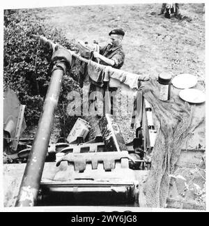 Un ÉQUIPAGE CHURCHILL PRÉPARE POUR LA BATAILLE LA VIE D'Un ÉQUIPAGE DE CHAR CHURCHILL - Trooper Macquinness arbore une ligne à travers l'avant du char sur laquelle traîner son linge. , Armée britannique, 21e groupe d'armées Banque D'Images