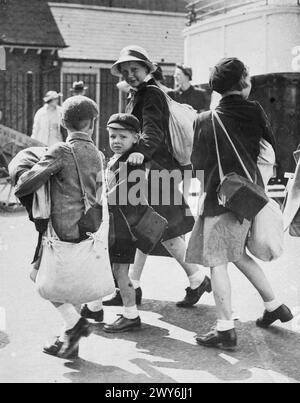 L'ÉVACUATION DES ENFANTS DU SUD-EST EN 1940. - Les enfants avec des étuis de masque à gaz et des effets personnels sur le point de monter à bord d'un train à Chatham. , Banque D'Images