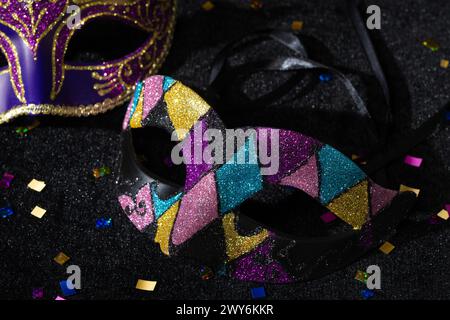 Vue rapprochée du masque Mascarade avec confetties sur fond noir. Banque D'Images