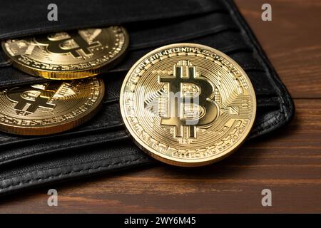 Vue rapprochée des pièces d'or Bitcoin dans le portefeuille sur la table. Banque D'Images