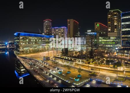 Photographie nocturne par drone à MediaCityUK, Salford Quays, y compris les BBC Studios, l'Université de Salford et le Dock 10 au premier plan Banque D'Images