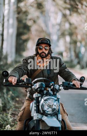 Un homme portant un casque noir assis sur une moto Banque D'Images