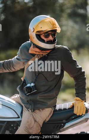 Un motocycliste en équipement de sécurité est assis sur son vélo Banque D'Images