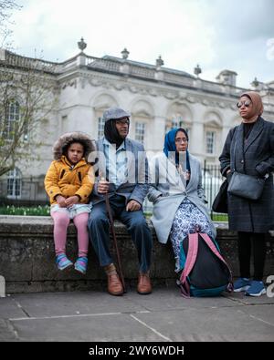 Un groupe familial de touristes s'est enveloppé chaleureusement pour visiter Cambridge Royaume-Uni Banque D'Images
