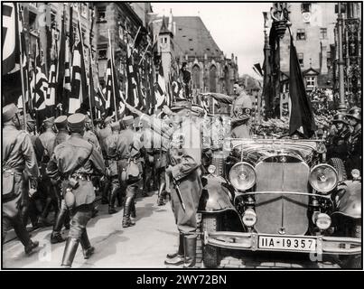 ADOLF HITLER Vintage Nurnberg Nuremberg Rallye 1935, Allemagne - sa Sturmabteilung troupes de milice politique du parti nazi, défilent devant Adolf Hitler lors d'un défilé du NSDAP dans la ville. Adolf Hitler des années 1930 portant un brassard Swastika dans la parade militaire, debout dans la voiture ouverte Mercedes donne Heil Hitler salut aux troupes de passage marchant Sturmabteilung, avec ses Waffen SS Guards debout derrière Nuremberg Nurnberg Allemagne Banque D'Images