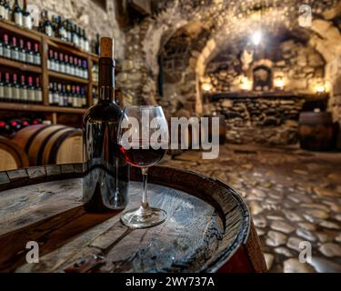 Un verre de vin se trouve au sommet d'un tonneau en bois. Banque D'Images