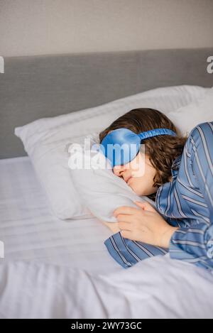 masque de sommeil en soie pour un sommeil confortable. la femme dort au lit à l'hôtel Banque D'Images