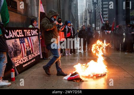 Le vétéran du corps des Marines Zachary Kam brûle un drapeau américain à l'hôtel de ville de Chicago lors d'un rassemblement pour « Annuler le DNC ». Banque D'Images