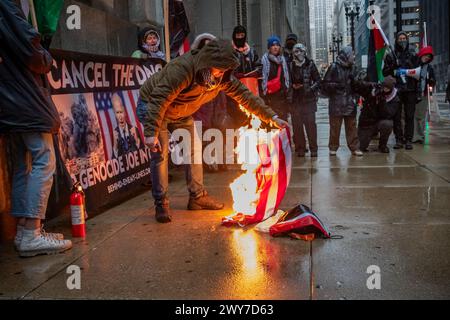 Le vétéran du corps des Marines Zachary Kam brûle un drapeau américain à l'hôtel de ville de Chicago lors d'un rassemblement pour « Annuler le DNC ». Banque D'Images