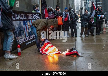 Le vétéran du corps des Marines Zachary Kam brûle un drapeau américain à l'hôtel de ville de Chicago lors d'un rassemblement pour « Annuler le DNC ». Banque D'Images