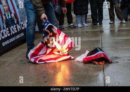 Le vétéran du corps des Marines Zachary Kam brûle un drapeau américain à l'hôtel de ville de Chicago lors d'un rassemblement pour « Annuler le DNC ». Banque D'Images