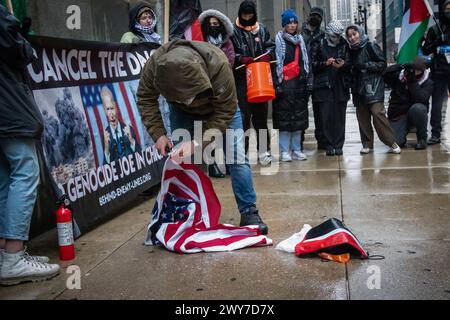 Le vétéran du corps des Marines Zachary Kam brûle un drapeau américain à l'hôtel de ville de Chicago lors d'un rassemblement pour « Annuler le DNC ». Banque D'Images