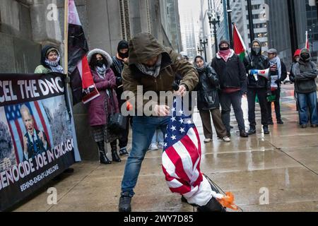 Le vétéran du corps des Marines Zachary Kam brûle un drapeau américain à l'hôtel de ville de Chicago lors d'un rassemblement pour « Annuler le DNC ». Banque D'Images