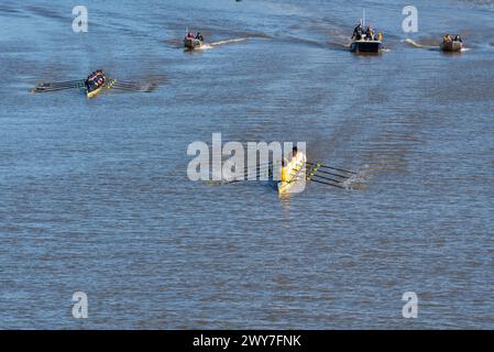 Cambridge (Goldie) menant Oxford (Isis) dans la course de bateaux de réserve masculins, suivi par les bateaux de chasse sur la Tamise à Mortlake près de l'arrivée Banque D'Images