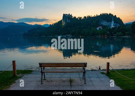 Coucher de soleil sur un banc regardant le château de Bled en Slovénie Banque D'Images