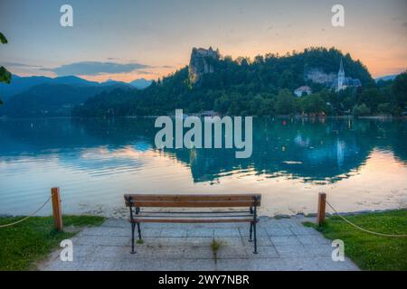 Coucher de soleil sur un banc regardant le château de Bled en Slovénie Banque D'Images