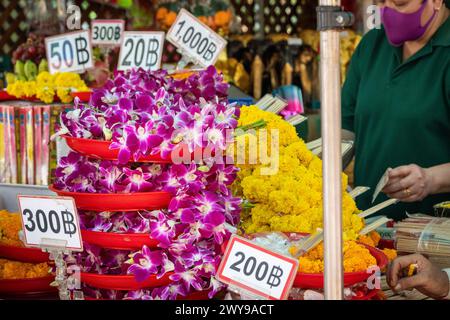 Exposition de fleurs en vente à offrir et leurs prix respectifs, au sanctuaire Erawan au centre-ville de Bangkok. Thaïlande. Banque D'Images