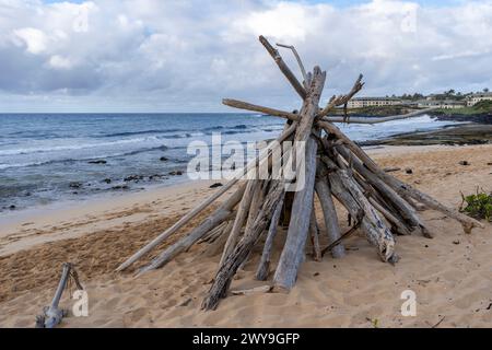 Un paquet de bois flotté est empilé et prêt pour un feu de joie sur Shipwreck Beach à Koloa, Hawaï. Banque D'Images