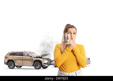 Jeune conductrice effrayée lors d'un accident de voiture avec les mains devant sa bouche isolée sur fond bleu Banque D'Images