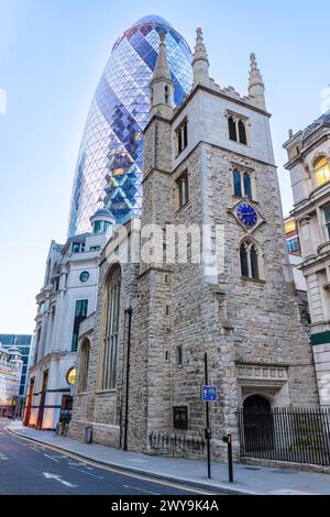 Londres, Royaume-Uni - 20 mai 2023 : St Andrew Undershaft Church au coucher du soleil dans la ville de Londres, et le Gherkin, officiellement 30 St Mary axe et précédemment connu Banque D'Images