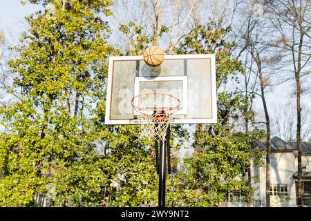 Panier de basket-ball extérieur avec balle dans l'air Banque D'Images