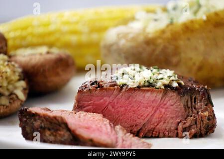 Filet mignon tranché avec côtés sur une assiette à dîner Banque D'Images