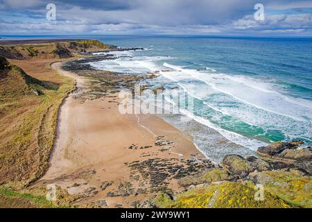 Sunnyside Beach Cullen Aberdeenshire Écosse vue sur la plage de rochers et de sable la mer bleu vert et la gorge jaune au printemps Banque D'Images