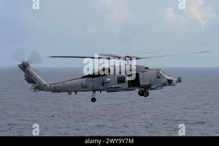 MER DE CHINE MÉRIDIONALE (27 mars 2024) un Sea Hawk MH-60R, affecté au « Wolf Pack » de l’Helicopter maritime Strike Squadron (HSM) 75, s’approche du Nimit Banque D'Images