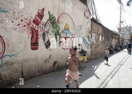 Enfants palestiniens courant la rue de peinture murale du camp de réfugiés de Sabra-Shatila au Liban Banque D'Images