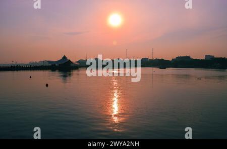 Beau coucher de soleil avec soleil orange dans le centre, plage d'Ancol, Indonésie Banque D'Images