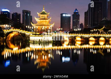 Guiyang, Chine - 09 février 2022 : la célèbre tour Jiaxiu et le pont Fuyu se reflètent sur la rivière au cœur du centre-ville de Guiyang dans le sud-ouest du C. Banque D'Images