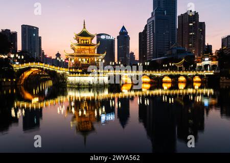 Guiyang, Chine - 09 février 2022 : la célèbre tour Jiaxiu et le pont Fuyu se reflètent sur la rivière au cœur du centre-ville de Guiyang dans le sud-ouest du C. Banque D'Images