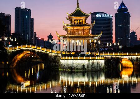 Guiyang, Chine - 09 février 2022 : la célèbre tour Jiaxiu et le pont Fuyu se reflètent sur la rivière au cœur du centre-ville de Guiyang dans le sud-ouest du C. Banque D'Images