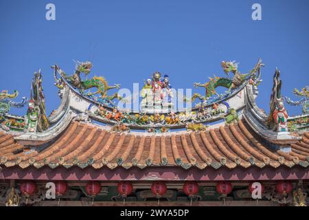 Un affichage vif des décorations traditionnelles chinoises de toit de temple avec des créatures mythiques contre un ciel bleu clair dans le temple de Mazu Banque D'Images