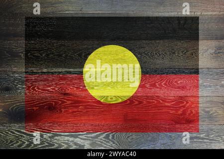 Drapeau aborigène australien sur fond rustique de vieux bois Banque D'Images