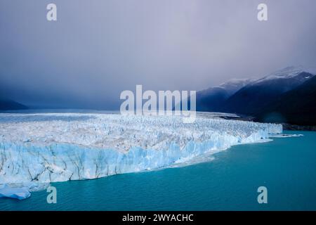 El Calafate, Patagonien, Argentinien - Perito Moreno Gletcher im Nationalpark Los Glaciares. Der Perito Moreno Gletscher gehoert zum patagonischen Eisfeld, dem Campo Hielo sur, der drittgroessten Suesswasserreserve der Welt. Er liegt in der Provinz Santa Cruz am Lago Argentino, dem groessten See des Landes. Der Perito Moreno Gletscher ist bis zu 30 km lang und 5 km breit. Seine Abbruchkante ist an der hoechsten Stelle 70 m hoch. Vom Gletscher abgebrochene kleine Eisberge treiben im Lago Argentino. Der Gletscher gehoert zu den schoensten Sehenswuerdigkeiten Suedamerikas und gilt als eine der me Banque D'Images