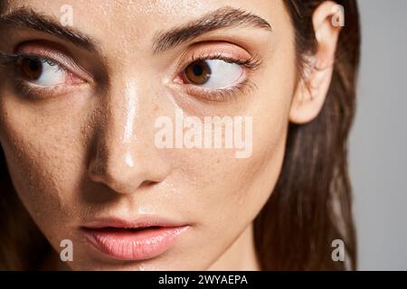 Un gros plan d'une jeune femme caucasienne aux yeux bruns fascinants, mettant en valeur sa beauté naturelle et ses traits frappants. Banque D'Images